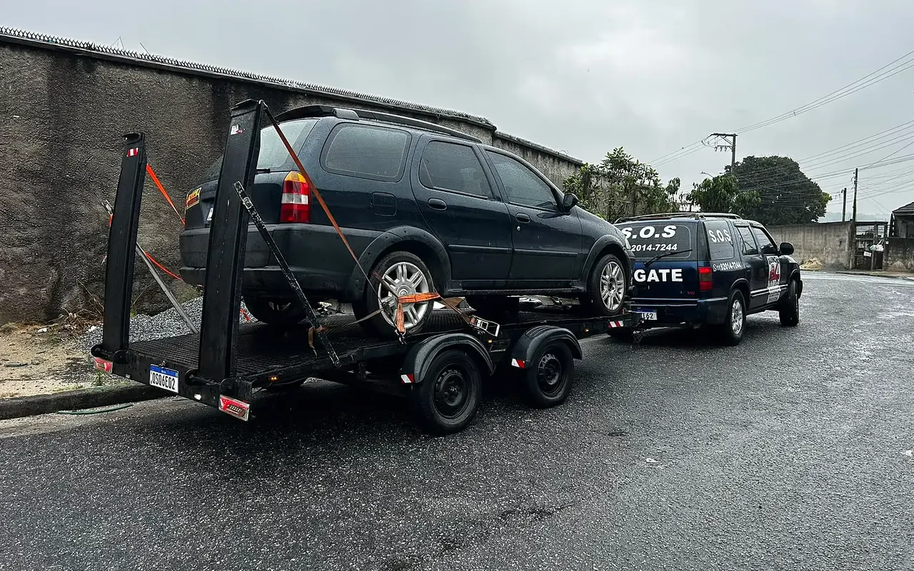 Blazer da MJC puxando o reboque-plataforma com uma minivan escura presa por cintas