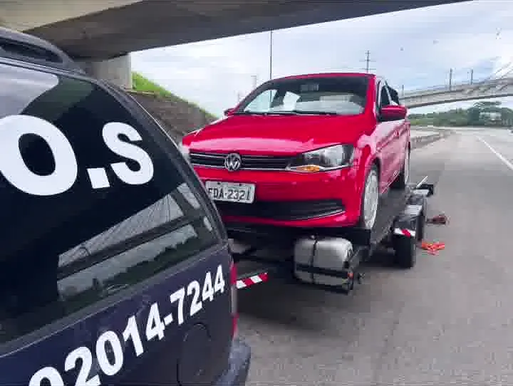 Hatch vermelho sobre a plataforma, com o S.O.S e o telefone da MJC na lataria da Blazer