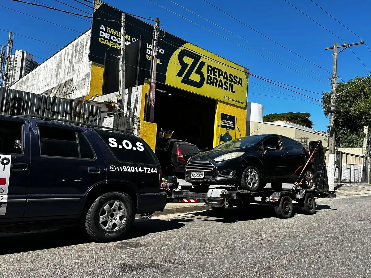Blazer da MJC com um hatch escuro na plataforma, em frente a uma loja da Repassa Brasil